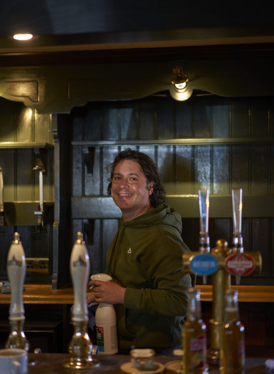 pub staff behind the bar serving drinks